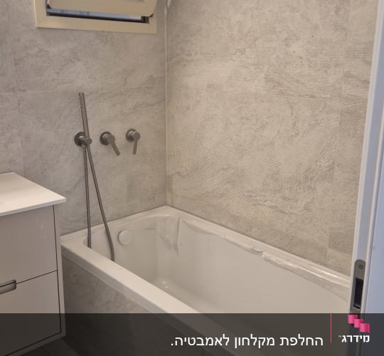 חדר אמבטיה עם אמבטיה וברזים